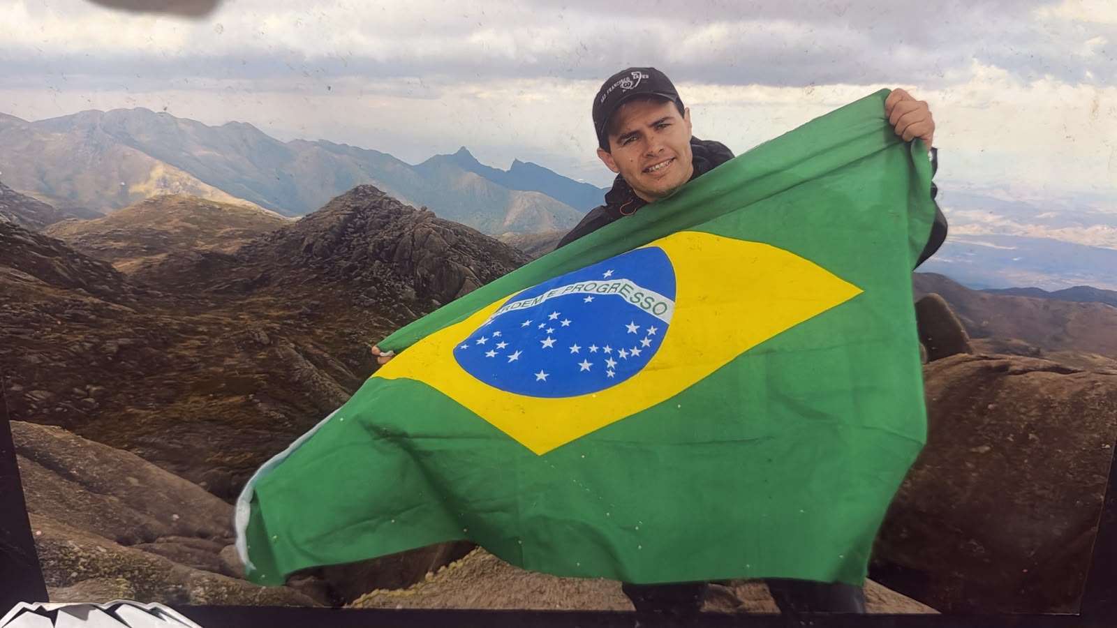 Priante Guia no cume com a bandeira do Brasil